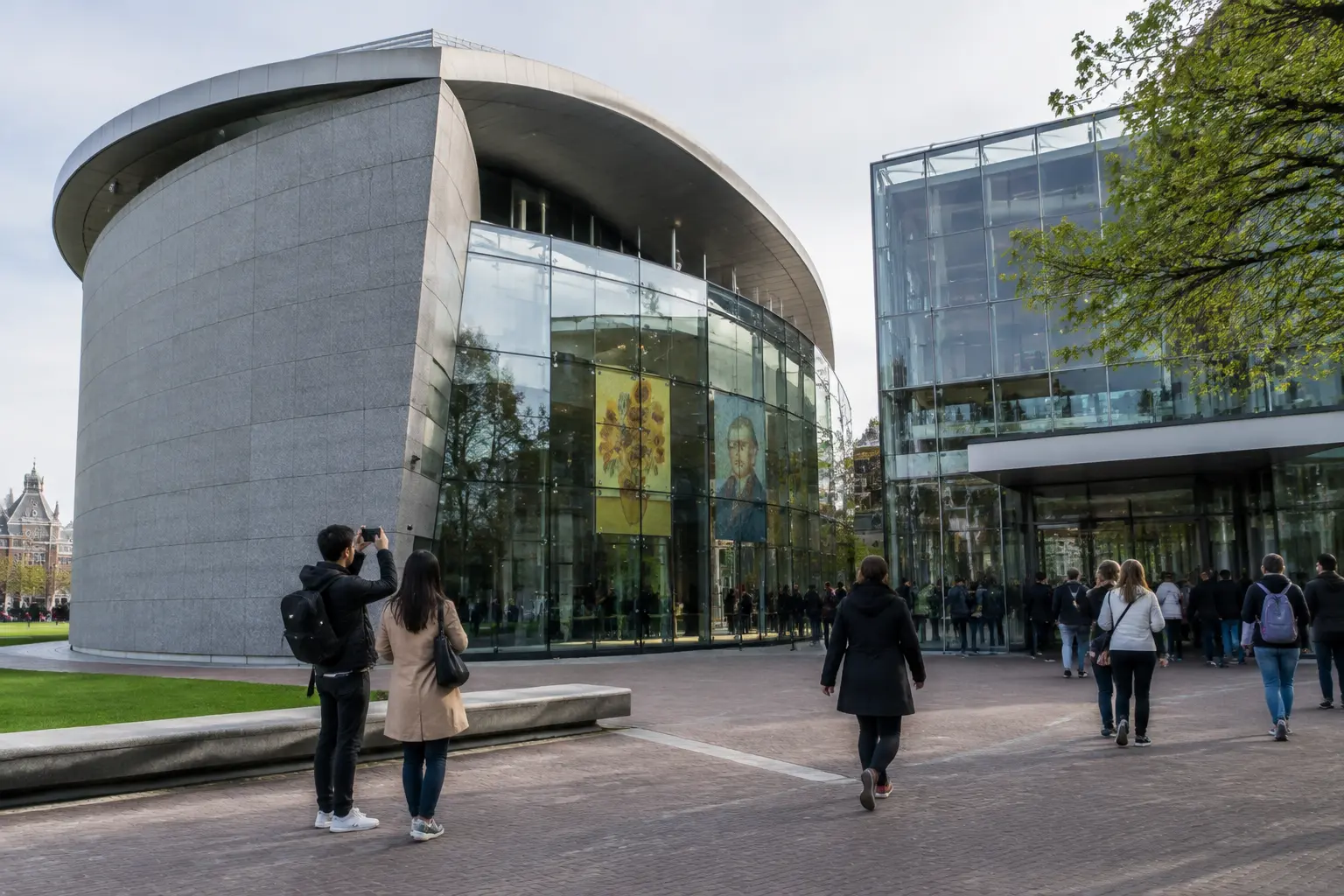 Посетители у музея Ван Гога на площади Museumplein в Амстердаме сверяют маршрут перед входом на заранее выбранный сеанс посещения.